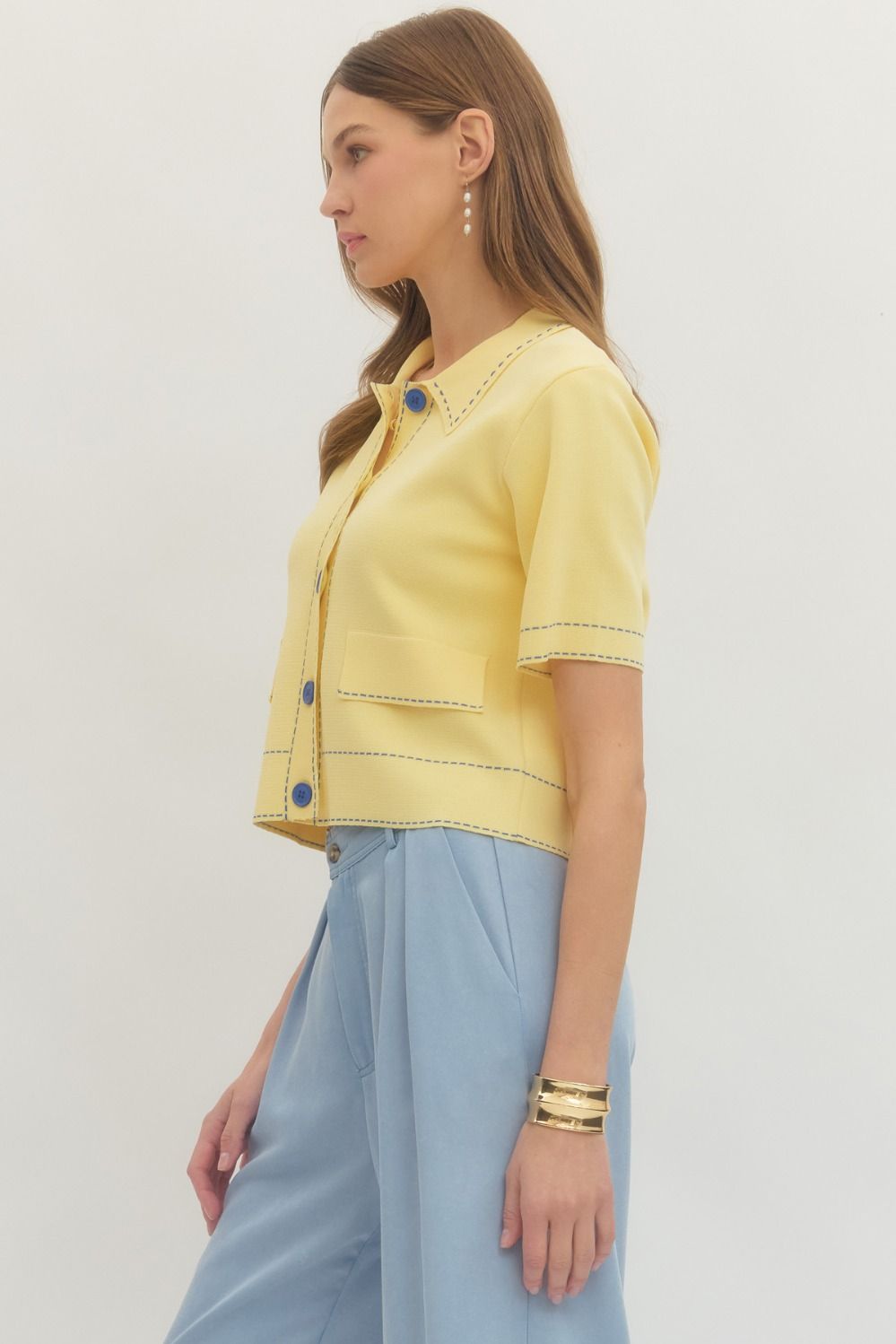 Solid short sleeve knit jacket featuring contrast stitch trim and button closure at front.
