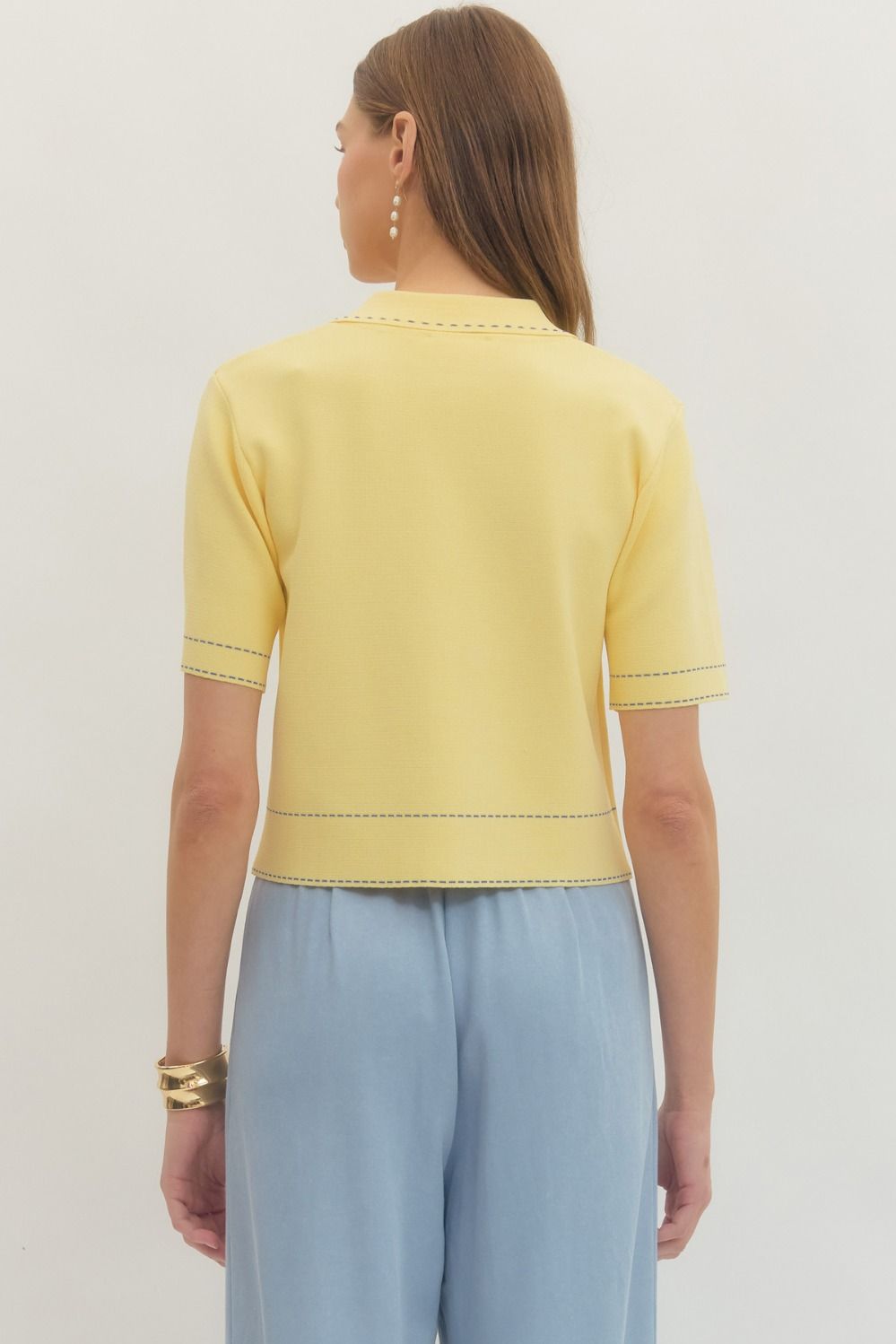 Solid short sleeve knit jacket featuring contrast stitch trim and button closure at front.