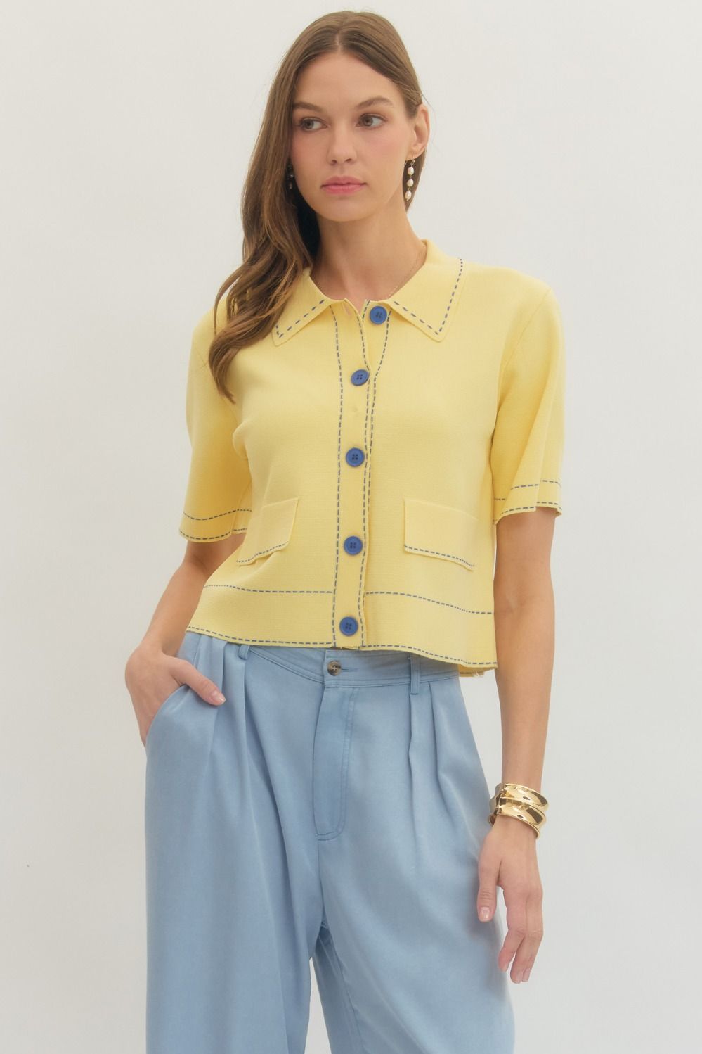 Solid short sleeve knit jacket featuring contrast stitch trim and button closure at front.