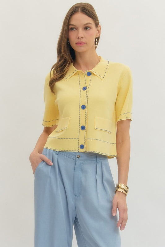 Solid short sleeve knit jacket featuring contrast stitch trim and button closure at front.